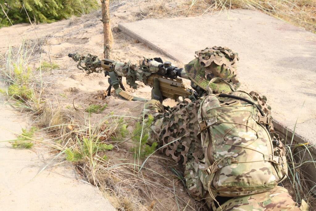Taktik kamuflaj nişancı, Lapua mühimmatı kullanarak arazi koşullarında uzun menzilli atış yapıyor